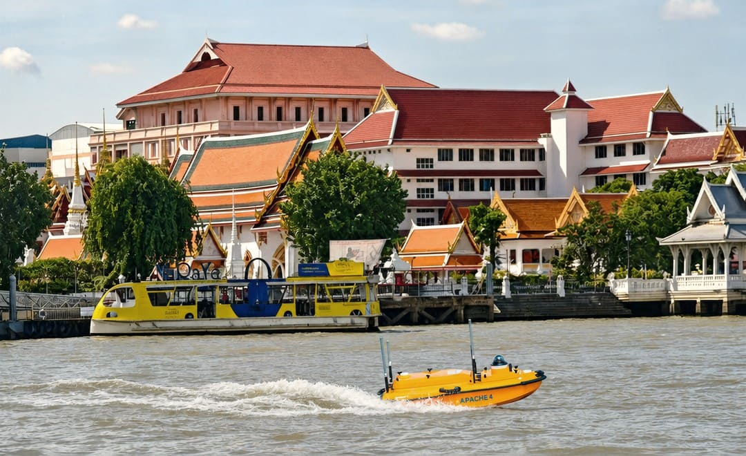 Helicóptero Apache 4 USV a sobrevoar o rio Chao Phraya, em Banguecoque, no meio do tráfego fluvial