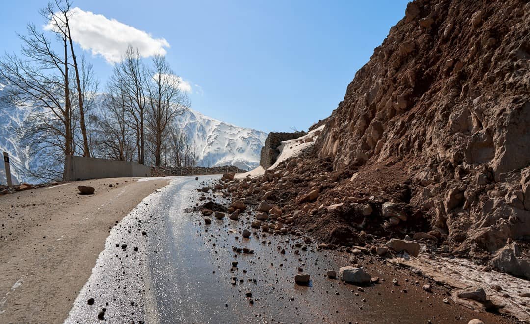 道路の一部を覆う土砂崩れの土砂やがれき。